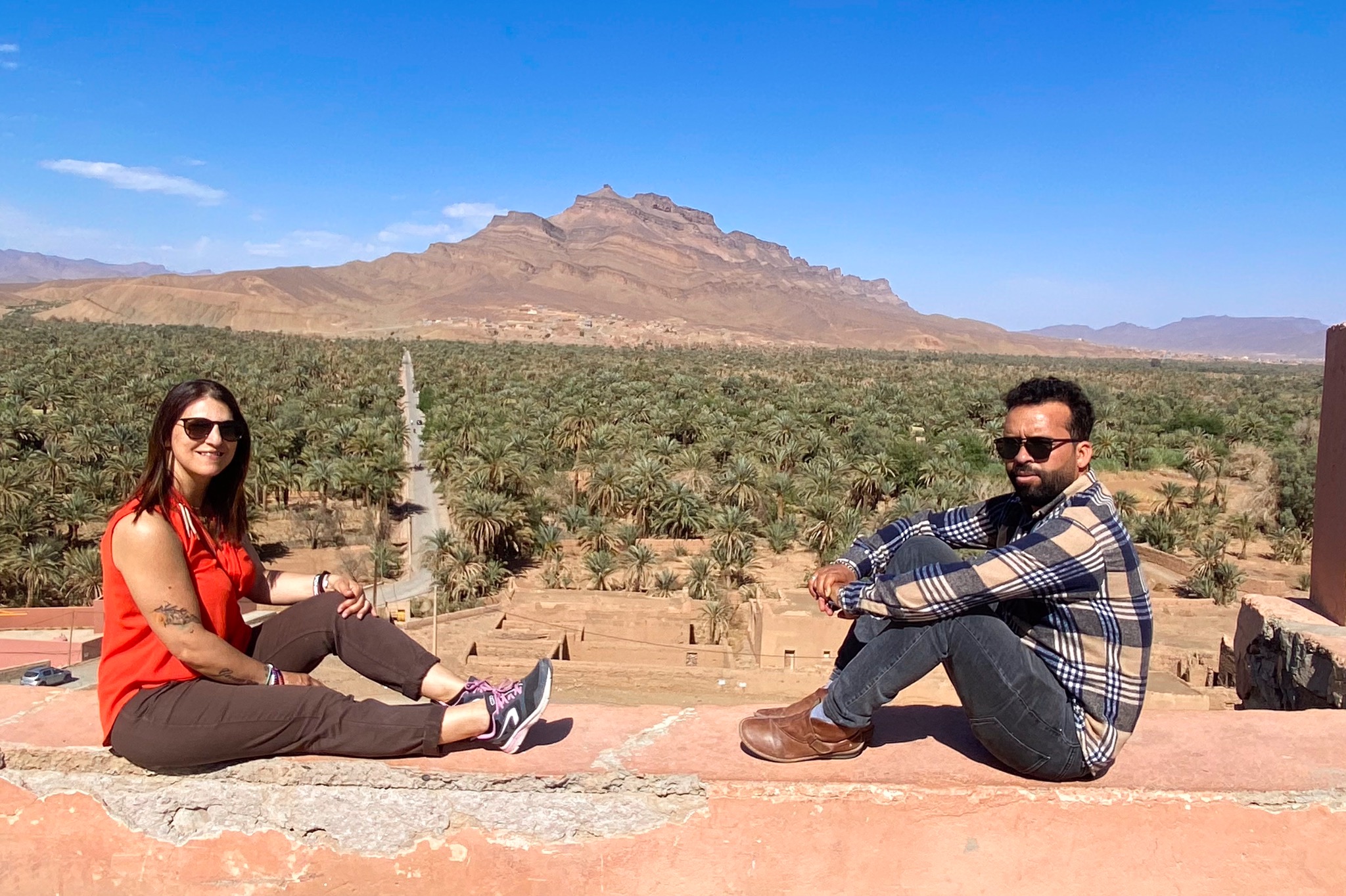 Sonia e Omar davanti a un palmeto e alle montagne del Marocco